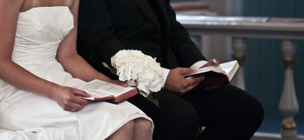 Kirkelig bryllup med salmebøker og blomster